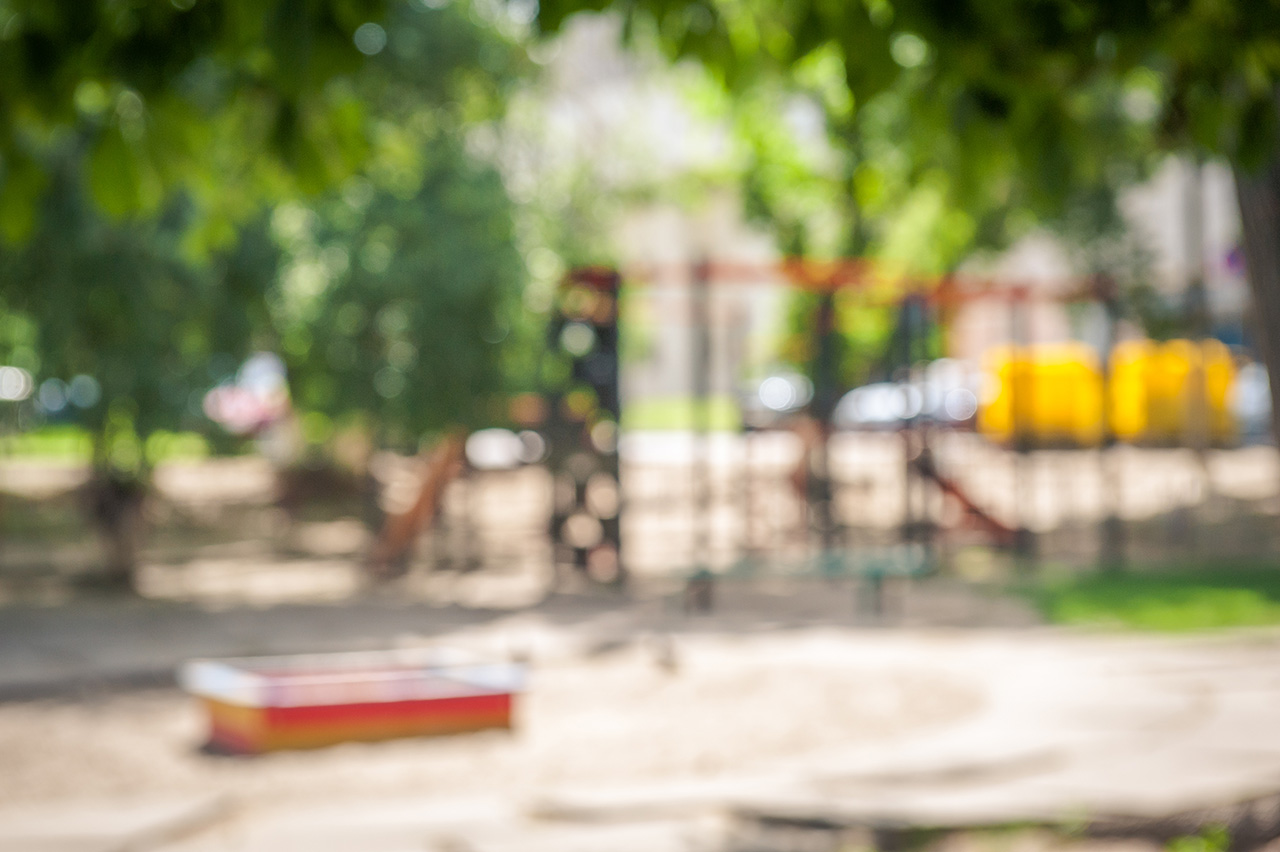 A slider located on the sand in summer. Defocused and blurred image for background of playground